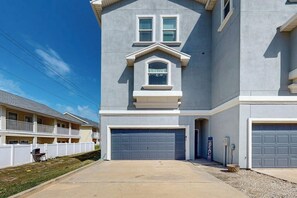 A two-story residential building with a garage, a balcony, and a small porch. - Padre Island 104 - Ocean Views, Walk to the Beach (Corpus Christi)