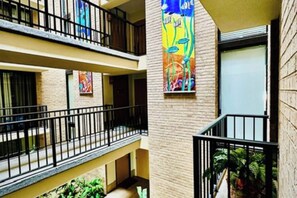 A multi-level hotel with balconies, a brick facade, and colorful artwork. - The Beach Condo #204 (South Padre Island)