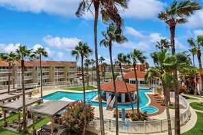 A hotel with multiple buildings, a central pool area, and surrounding palm trees. - Gulf Point Condominiums #3308 (South Padre Island)