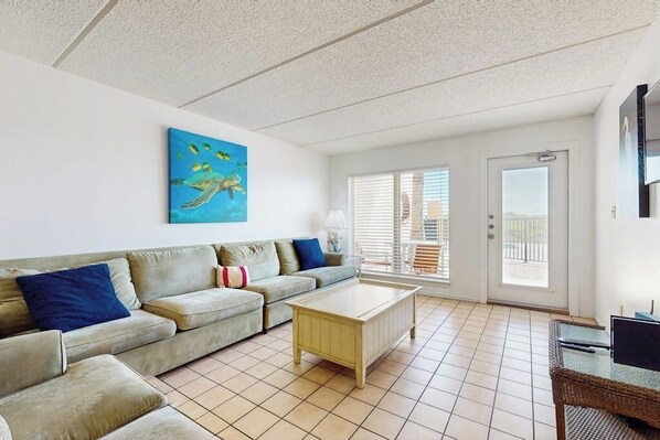 Ein Wohnzimmer mit einer Couch, einem Couchtisch und einem Bild an der Wand.