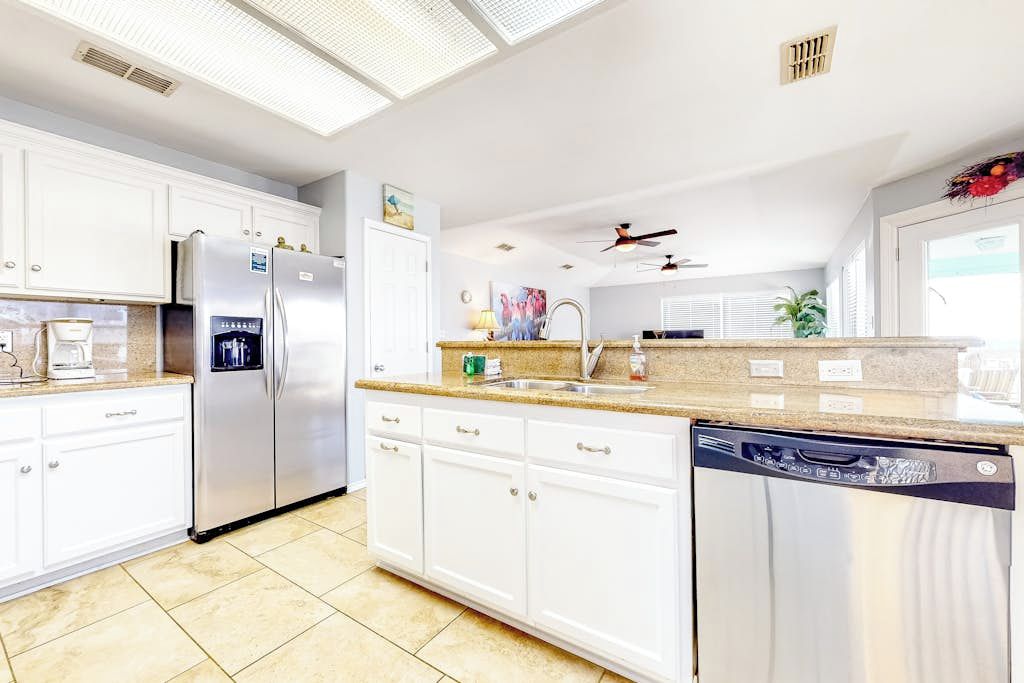 A modern kitchen with white cabinetry, stainless steel appliances, and a dishwasher.