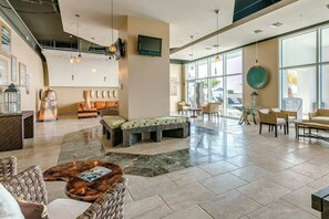 Eine geräumige Lobby mit einer Sitzecke, einem Empfangsbereich und einem an der Wand befestigten Fernseher.