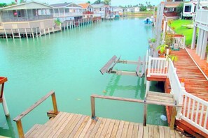 Una propiedad frente al agua con varias lanchas amarradas, una terraza de madera y vista al mar.