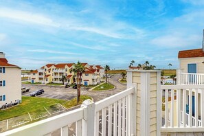A residential area with multi-story buildings, a parking lot, and a clear sky. - Beach Club 363 - Heated Pool & Hot Tub, Dogs OK (Corpus Christi)