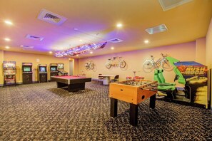 A room with a foosball table, pool table, and arcade games. - The Blue Diamond - Lazy River Pool & Game Room (Galveston)
