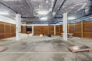 Ein geräumiger Raum mit Betonboden, Holzvertäfelung und einem Schachbrett in der Mitte.