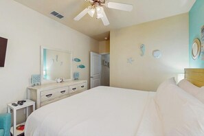 A bedroom with a bed, a dresser, a ceiling fan, and wall decorations. - Palm Bay 407 & 408 - Two Units, Pool, Sleeps 12 (Corpus Christi)