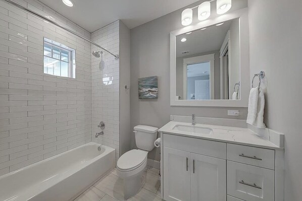 Un bagno moderno con vasca, WC e lavabo.