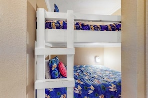 Ein Etagenbett mit zwei Schlafstellen, jede mit einer gemusterten Bettdecke.