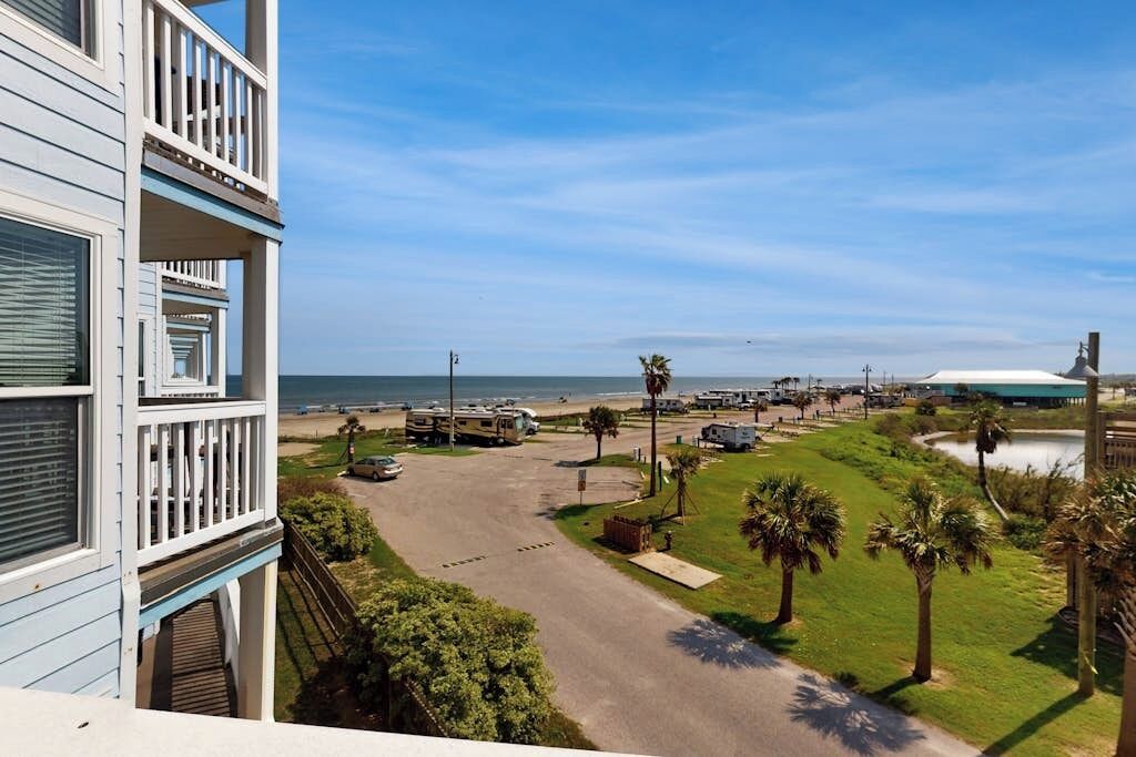 Ein Anwesen am Strand mit einer Zufahrtsstraße, einem Parkplatz und Blick auf den Ozean.