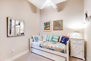 A bedroom with a bed, a nightstand, a dresser, a ceiling fan, and wall art. - Emerald by the Sea #806 (Galveston)
