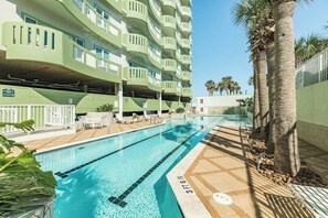 A swimming pool with a clear blue waterline, surrounded by a tiled deck area. - Seaside Oasis - Gulf Views, Pool & Fishing Pier (Galveston)