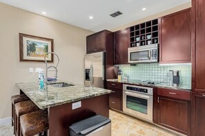 Eine Küche mit Granit Arbeitsplatte, Edelstahlgeräten und Holzschränken.