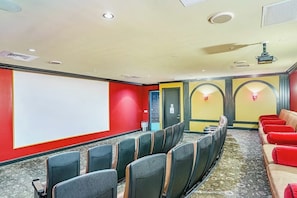 A conference room with rows of chairs, a projector screen, and a carpeted floor. - Diamond Beach Resort - Lazy River View #419 (Galveston)