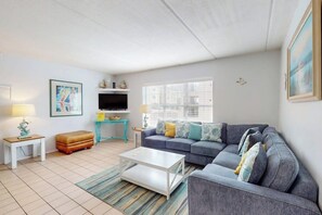 A living room with a sofa, coffee table, and a television. - Fiesta Sol Condominiums #109 (South Padre Island)