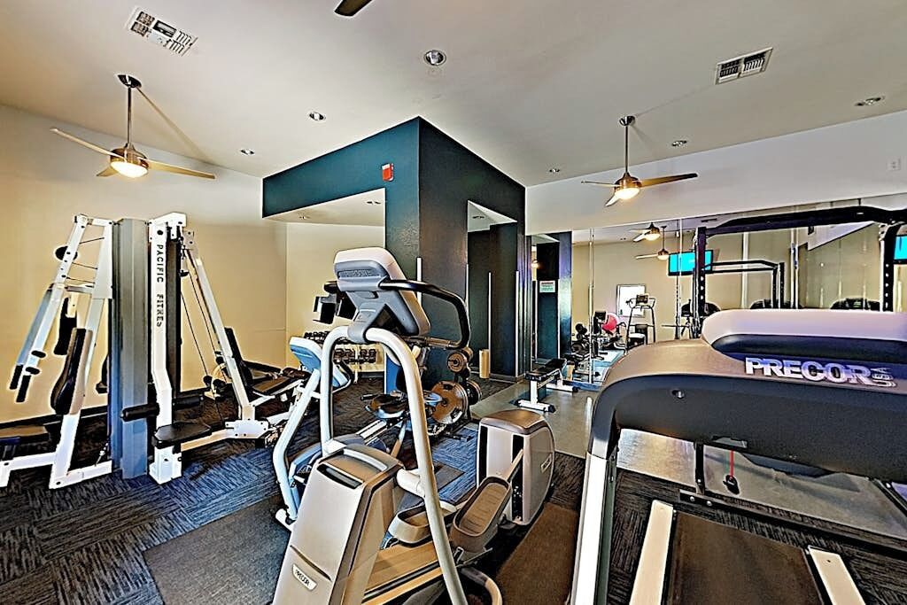 A gym with various exercise equipment, including treadmills and weight machines.