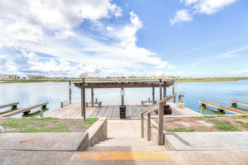 A waterfront park with a wooden deck, benches, and a gazebo.