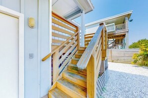 A wooden staircase leading to a building with a balcony. - Lilac Sky - Water Views, Pool & Dogs OK (Port Aransas)