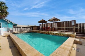 A swimming pool with a wooden deck, lounge chairs, and umbrellas. - Casa de la Encla - Anegada (Corpus Christi)