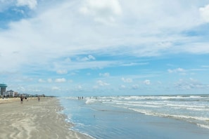 A beach with a lighthouse, sandy shore, and a clear sky. - Sandpiper Villa - Beach Views, Pool, Dogs OK (Galveston)
