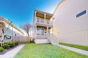 Ein zweistöckiges Wohnhaus mit Veranda und einer Treppe, die zum zweiten Stock führt.