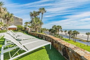 Un hotel con piscina, palmeras y vista a la playa.