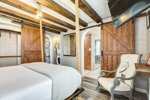 Ein Schlafzimmer mit einem Bett, einem Stuhl und Holzwänden.