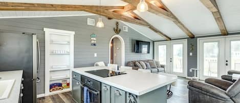 A modern kitchen with a central island, built-in appliances, and a dining area with a sofa.
