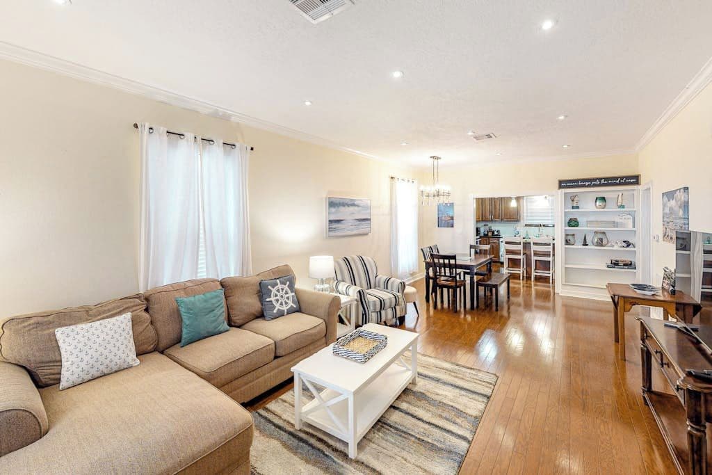 A living room with a sofa, coffee table, and dining area with chairs and a table.