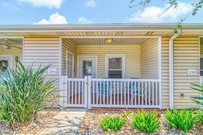 A single-story building with a covered porch, numbered 306 and 305, and a small outdoor seating area. - Palm Bay 306 - Pool & Patio, Short Walk to Beach (Corpus Christi)