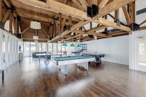 A spacious indoor area with a pool table, a billiards table, and a hammock. - Gulf Point Condominiums #1314 (South Padre Island)