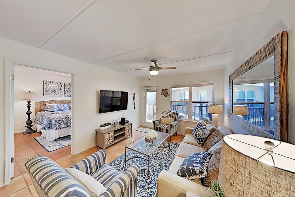 A spacious living room with a sofa set, a coffee table, and a television.