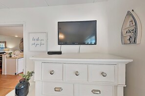 A white dresser with drawers and a flat-screen TV mounted above it. - Surfside I Condominiums #301 (South Padre Island)