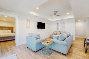 A modern living room with a sofa, a coffee table, and a ceiling fan. - Carolyn's Beach House unit A (South Padre Island)