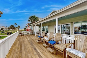 A wooden deck with outdoor seating and a view of the ocean. - Piper's Place - Short Walk to Beach, Dogs OK (Galveston)