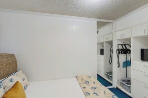 A bedroom with a bed, a wardrobe, and a bathroom area. - Seawall Treasure - Heated Pool & Private Balcony (Galveston)