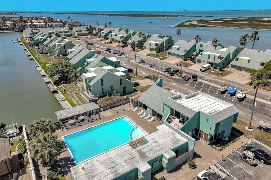 Een kusthotel met meerdere gebouwen, een zwembad en een jachthaven.