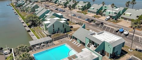 Een kusthotel met meerdere gebouwen, een zwembad en een jachthaven.