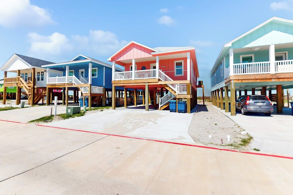 A beachfront property with multiple houses, each with a balcony and a wooden deck.