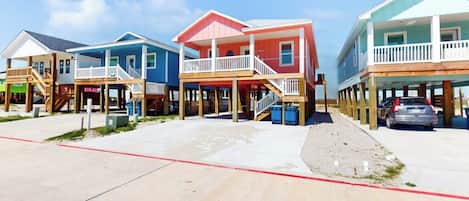 A beachfront property with multiple houses, each with a balcony and a wooden deck.