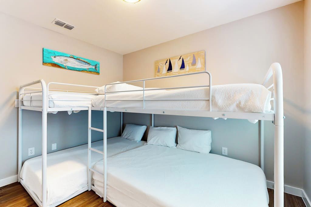 Camera con letto a castello e un quadro raffigurante pesci e barche a vela sulla parete.