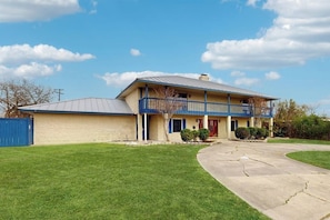 A two-story house with a front porch, a garage, and a well-maintained lawn. - Sunshine Shores - Pool Table, Yard & Dogs OK (Corpus Christi)