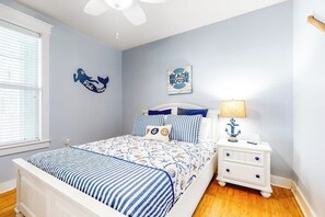 A bedroom with a bed, nightstand, and wall decorations. - Pointe West Resort - Peaceful at the Pointe (Galveston)