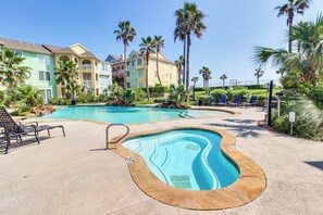 A swimming pool with lounge chairs and palm trees. - Dawn Condominiums - The Perfect Dawn (Galveston)