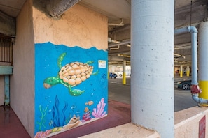 A parking garage with a mural of a turtle on a column. - Seahab, Maravilla Resort, Pools, Hot Tub, Beach (Galveston)