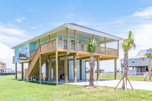 A two-story house with a balcony and a covered outdoor area. - Vacationers Valhalla (Galveston)