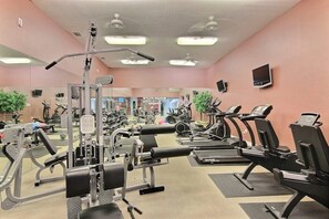 A gym with various exercise equipment, including treadmills and weight machines, and a mirror on the wall. - Beach Club 155 - Pool & Hot Tub, Close to Beach (Corpus Christi)
