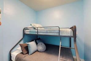 A bunk bed with a mattress, pillows, and a blanket. - Blue Dolphin Beach House (South Padre Island)