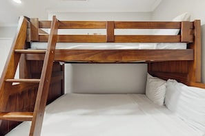 A bunk bed with a wooden ladder, white bedding, and a headboard. - Dolphin Condominiums #5 (South Padre Island)
