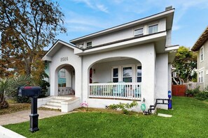 Une maison de plain-pied avec un porche à l’avant, une boîte aux lettres et un petit jardin.